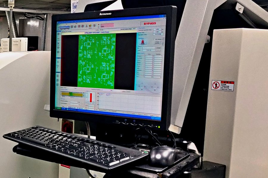 Automated optical inspection station reading a populated board